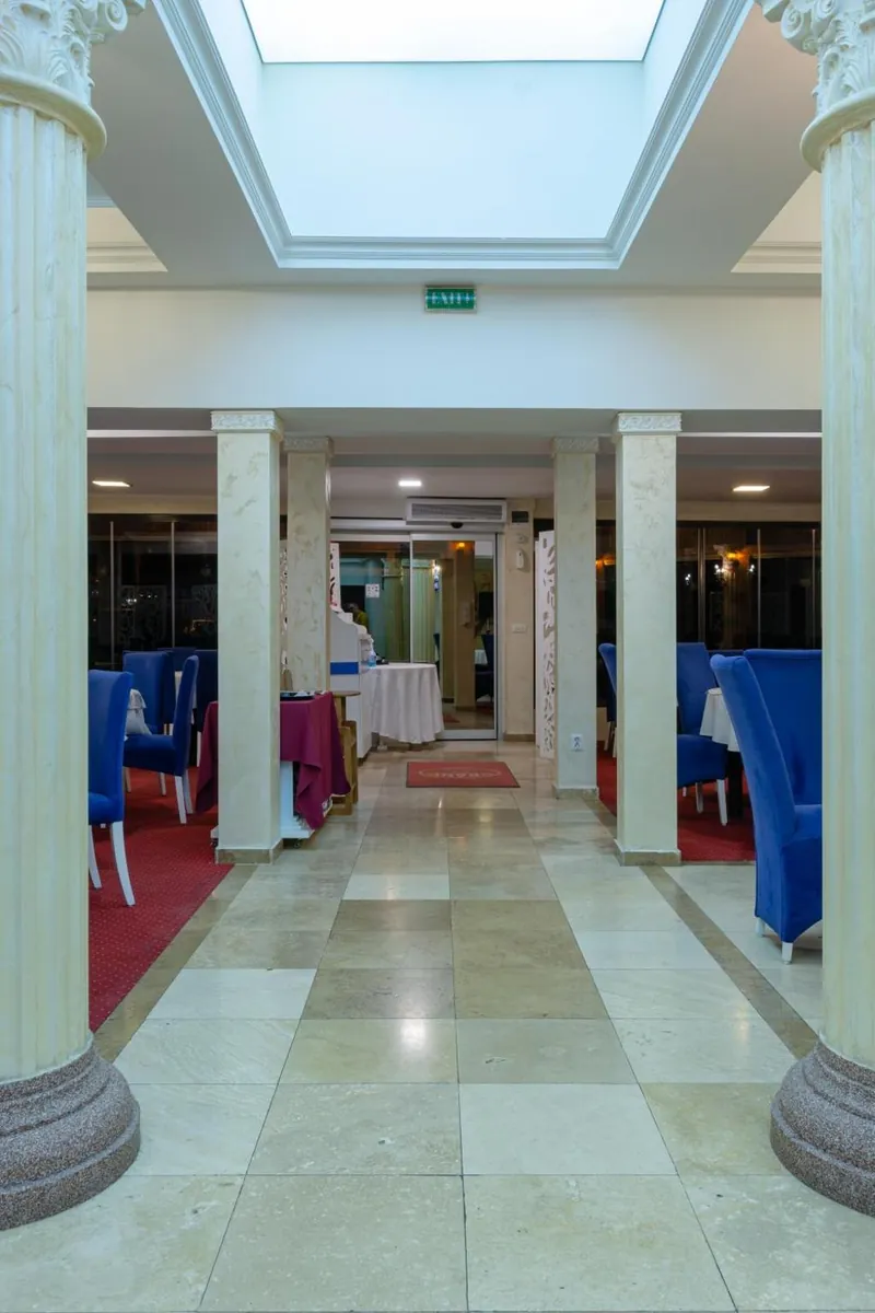 Holul cu coloane și luminator care duce spre salonul restaurantului