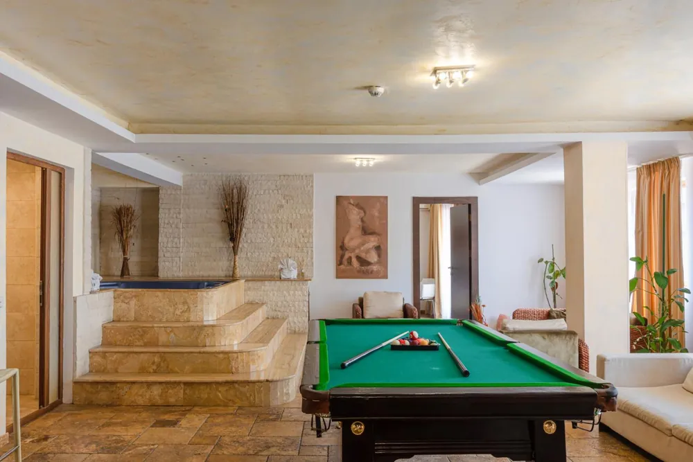 Super Spa: masă de biliard, canapele albe și jacuzzi pe trepte de piatră