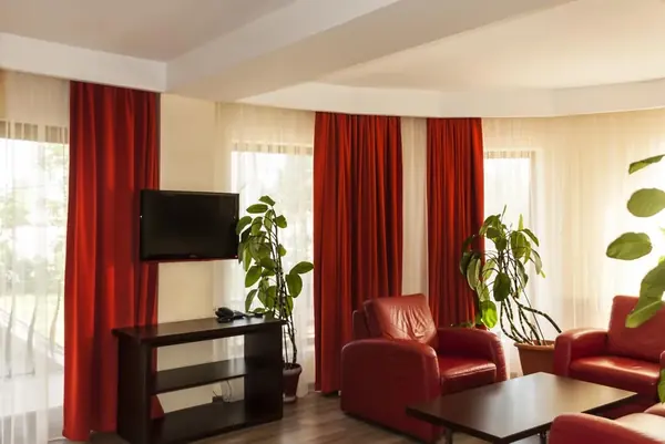 Livingul apartamentului cu fotolii roșii