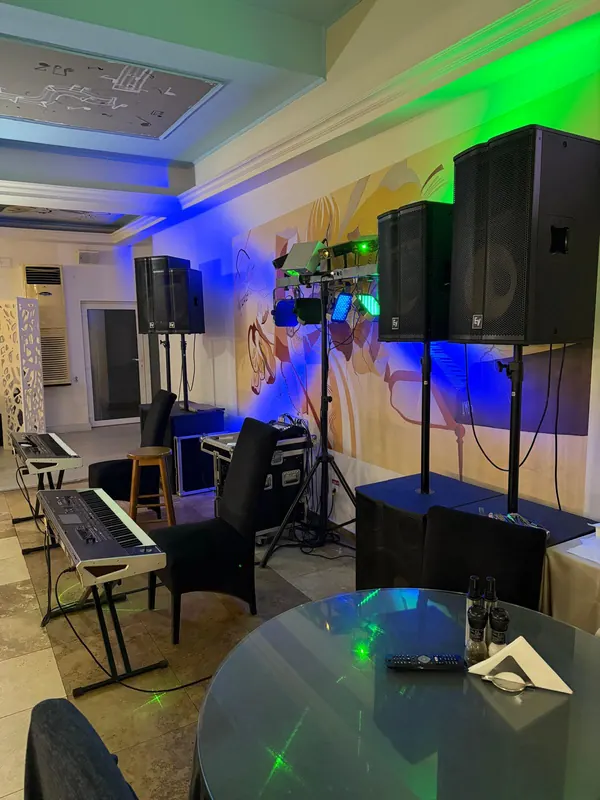 Scena de muzică live din restaurant, cu claviaturi, boxe și lumini