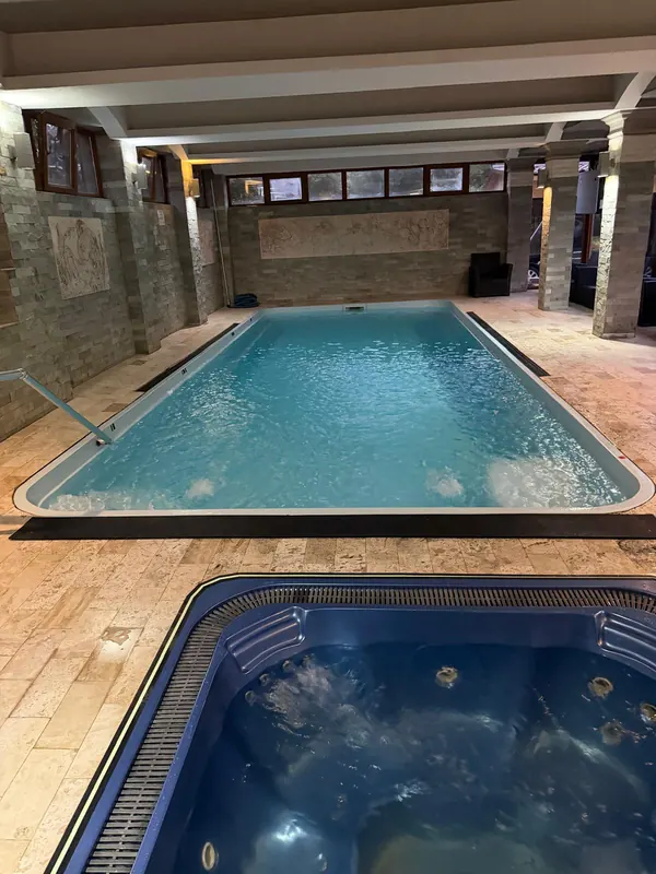 Piscina interioară încălzită, cu jacuzzi în prim-plan