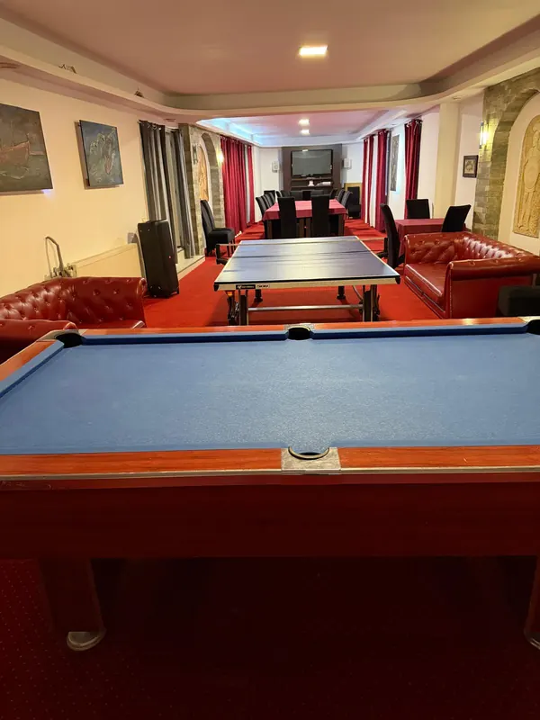 Sala de jocuri, cu biliard, tenis de masă și canapele din piele
