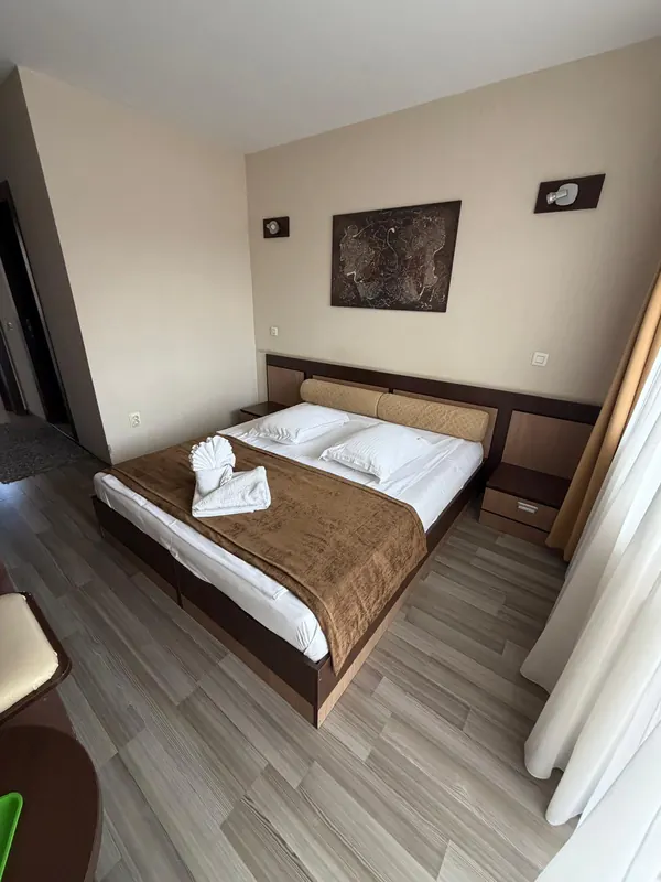 Pat matrimonial cu prosoape aranjate și tablou deasupra